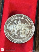 Obverse of commemorative coin with hockey player and Kingston City Hall