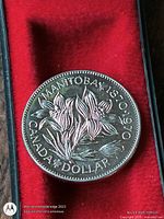 Reverse of 1970 Manitoba Centennial dollar in red felt holder