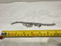 Full view of charm bracelet with tape measure showing length