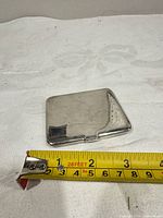 Closed Birks sterling cigarette case next to measuring tape