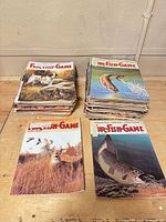 Two stacks and two laid-out Fur-Fish-Game magazines showing cover art