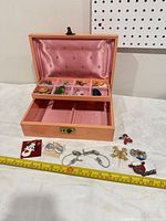 Overall view of jewelry box open with jewelry pieces laid out