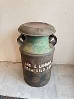 Front view of Lanark Creameries milk can showing lid and stencilled lettering
