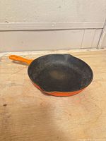 Top view of skillet showing interior wear and orange enamel sides