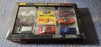 Front view of sealed Maisto Power Racer box with vehicles visible