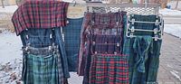 All six tartan kilts and sash on outdoor rack