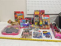 Overall lot view displaying sealed Marvel, Barbie, WWE, Hot Wheels items, loose She-Ra figures and carry case