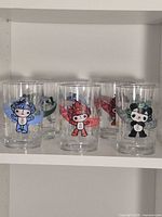 Front view of six Fuwa mascot glasses on shelf