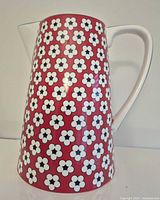 Full front view of floral porcelain pitcher showing pattern and handle