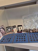 Overall view of coin folders, bag of pennies, RCM coin cases and booklet