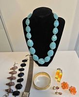 Full lot overview showing necklace on bust, bracelets and earrings laid out