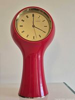 Full view of red Secticon pedestal clock front showing dial and housing
