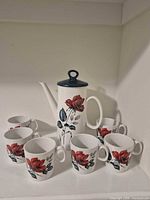 Coffee pot with six cups displayed together