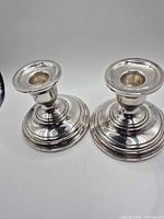 Front view of both candlestick holders showing overall form and finish