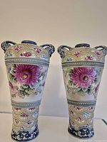 Front view of both matching moriage vases showing floral design and handles