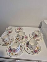 Full set arranged; five cups with saucers, cream jug, sugar bowl
