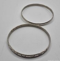 Both sterling silver bangles showing engraving detail