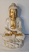 Front view of white and gold seated Buddha statue