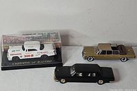 Group shot of three diecast cars: packaged Legends of Racing Chrysler 300B, gold Mercedes-Benz 600, black Mercedes-Benz 600