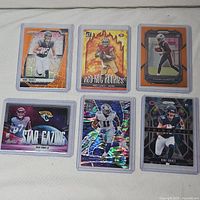 Six football trading cards in toploaders laid out