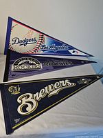 Three pennants Dodgers Rockies Brewers displayed overlapping