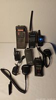 Group shot of six handheld radios and two speaker microphones