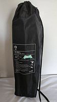 Full view of black drawstring carrying bag standing upright