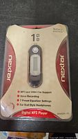 Front of sealed package showing Nextar 1 GB digital MP3 player and included earbuds