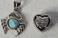 Crab charm alongside heart charm showing reverse engraving
