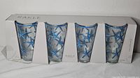 Front view of boxed set showing four glasses with blue starfish design