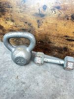 Front view of both dumbbells showing size difference and surface wear