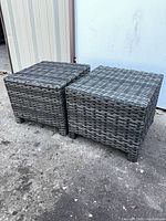 Two synthetic wicker cube tables side by side on concrete