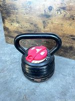 Front view of Peakform adjustable kettlebell showing red dial and stacked plates