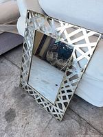 Full view of mirror showing lattice metal frame and glass