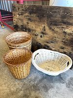 Three baskets: two tan cylindrical and one white oval