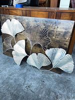 Front view showing entire metal leaf artwork on wood panel