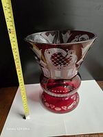 Full view of vase beside tape measure indicating 11 in height
