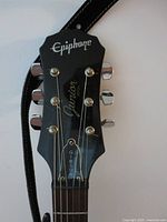Headstock showing Epiphone logo, Junior script, tuners, serial area