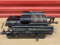 Left-front view showing full calculator, number registers, crank and Triumphator PR logo