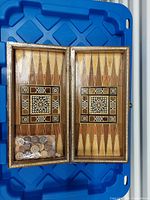 Board open showing backgammon interior and bag of playing pieces