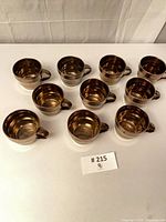All ten bronze Starbucks mugs displayed top view