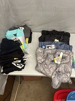 Group photo showing stacks of Head leggings and 32 Degrees Heat vests on table