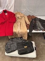 All four coats and two leather bags displayed together