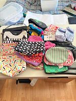 Tabletop view showing all assorted pouches, fanny packs and purses with various patterns and colours