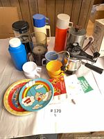 Group shot of espresso maker, thermoses, cups, plates