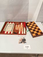 Open backgammon case, folded chessboard, bagged chess pieces