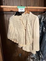 Shawl draped over shoulder of jacket on hanger