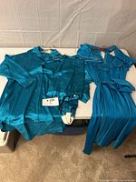 Blouse, stirrup pants and dress laid out on table