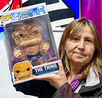 Woman holding boxed 10" Funko Pop The Thing showing scale and protector sleeve