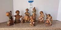 All eight carved wood figurines lined up